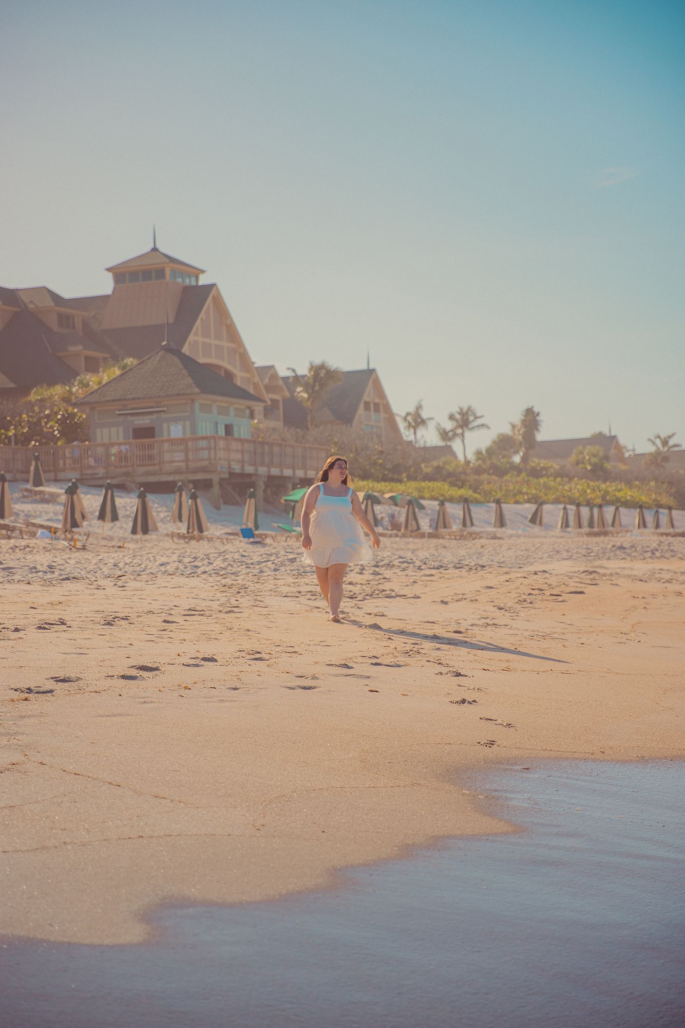 A girl walks down the beach from Disney's Vero Beach Resort during a family photo session