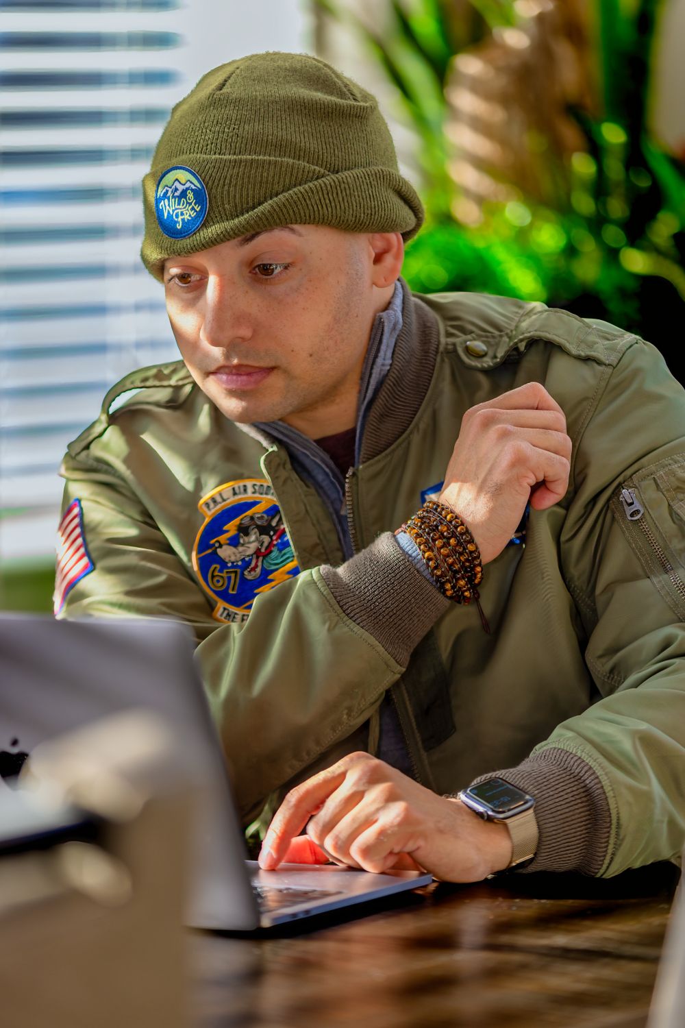 A Boy Scout in uniform studying or working at a desk with patches visible on sleeve.