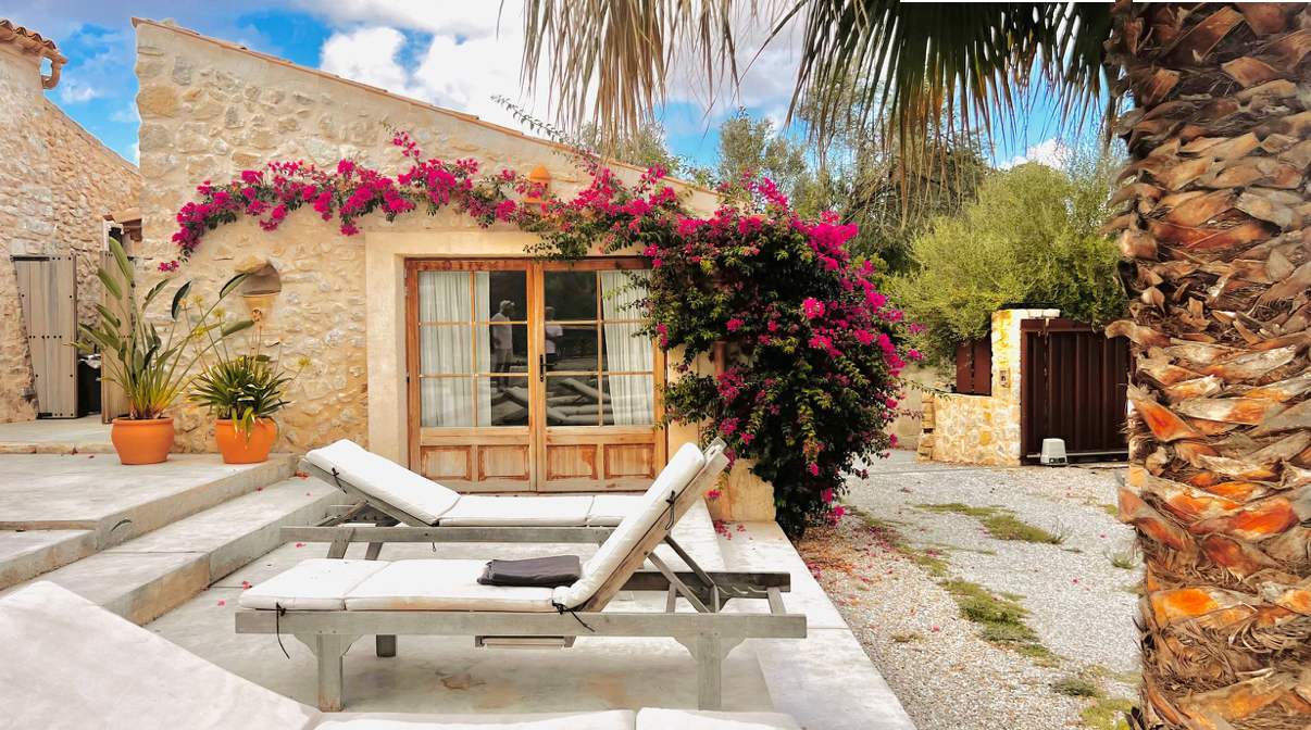 Contemporary white villa with swimming pool and sun loungers on a sunny terrace.
