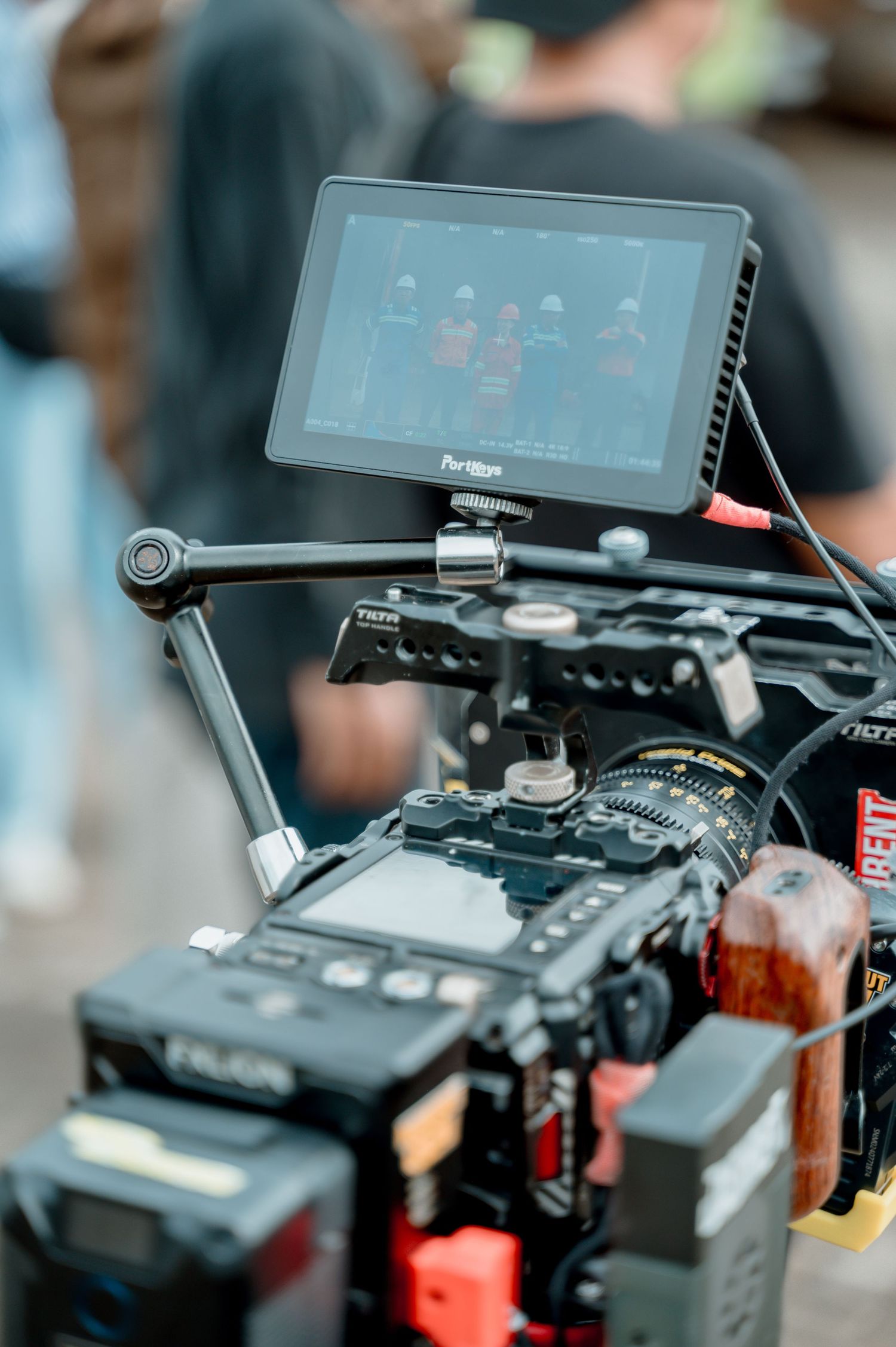 Close-up of a professional cinema camera rig with monitor displaying footage on a film set.