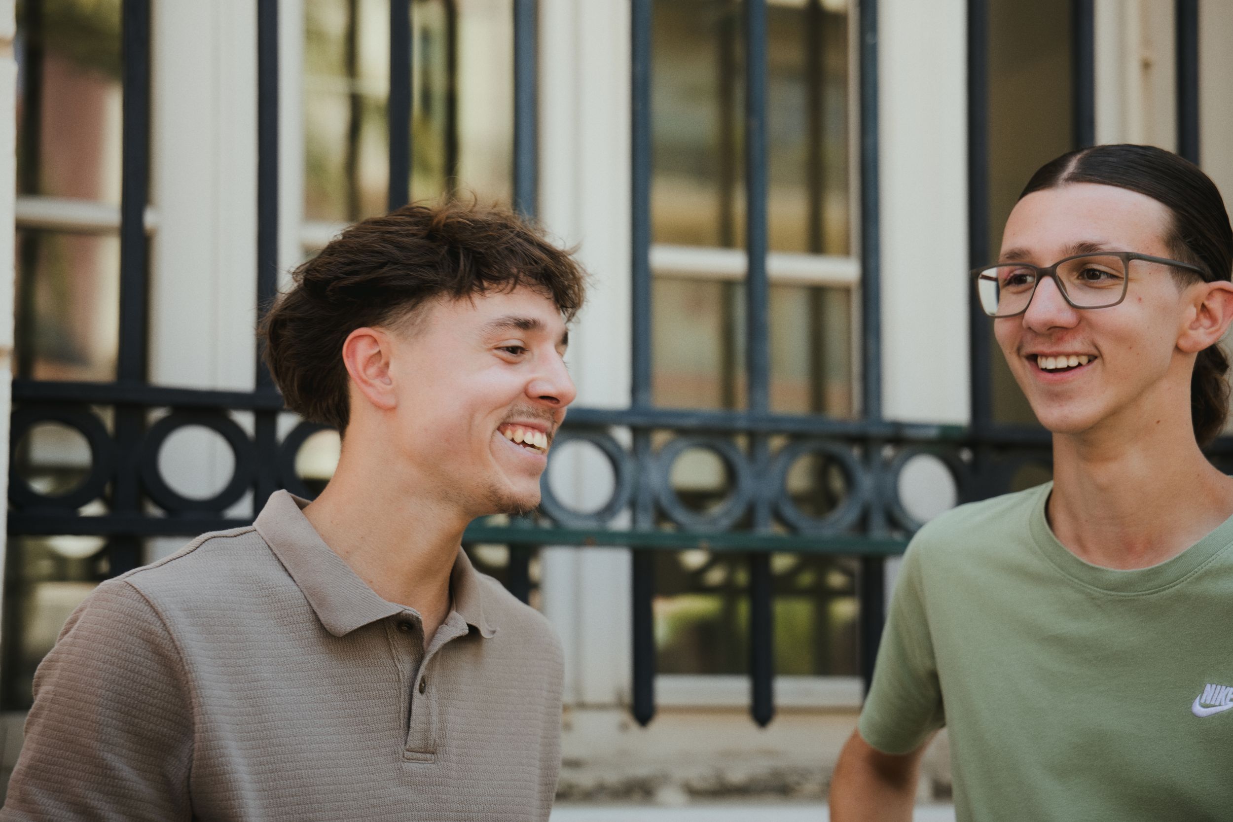 Deux invités échangent un sourire devant les grilles de la mairie