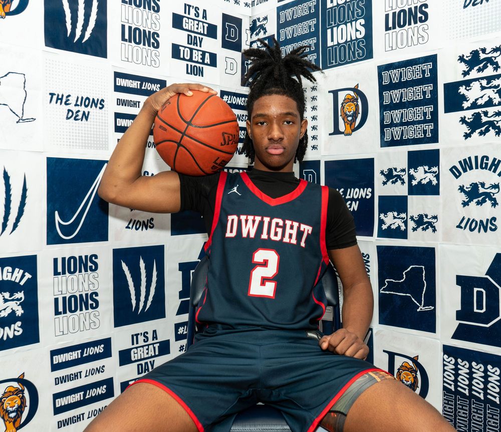 Basketball player in Dwight #2 jersey poses with ball in front of Lions Den branded backdrop.