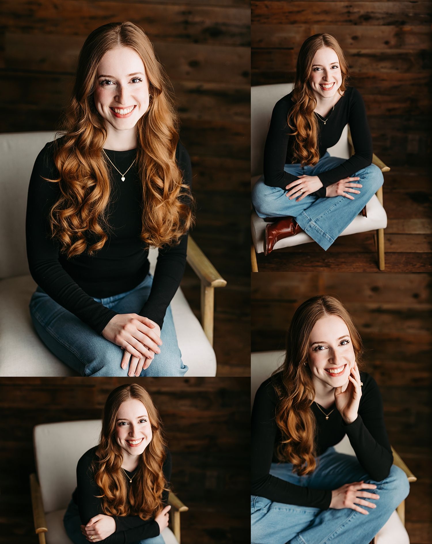 Young woman with long red hair in black top and jeans poses in white chair against rustic wood wall.