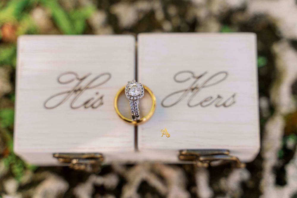 A diamond engagement ring positioned between two white cards with 'His' and 'Hers' text.