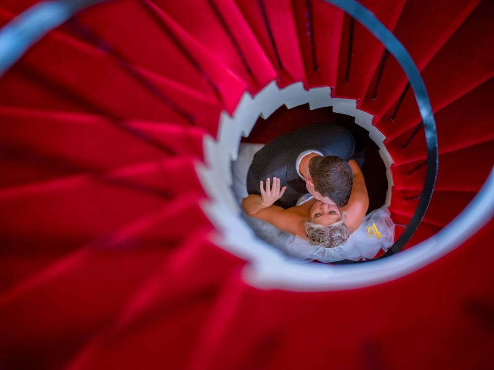 A spiral staircase photo with red carpet creating leading lines and dramatic perspective.