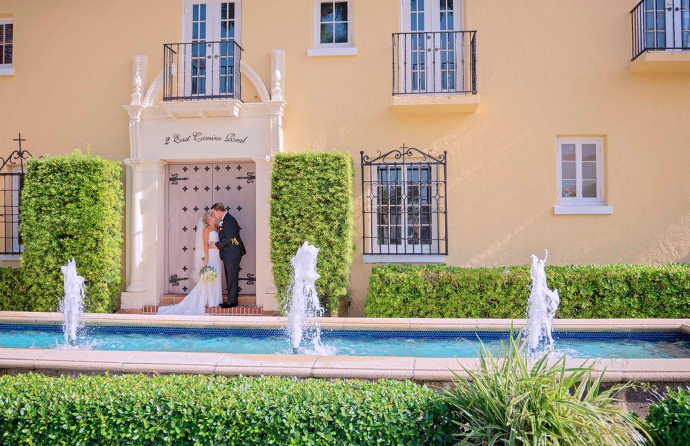 An elegant wedding scene with fountains and Mediterranean architecture.