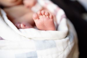 Close-up of tiny newborn baby feet wrapped in a soft white and gray blanket  at Tennova North Knoxville Medical Center.