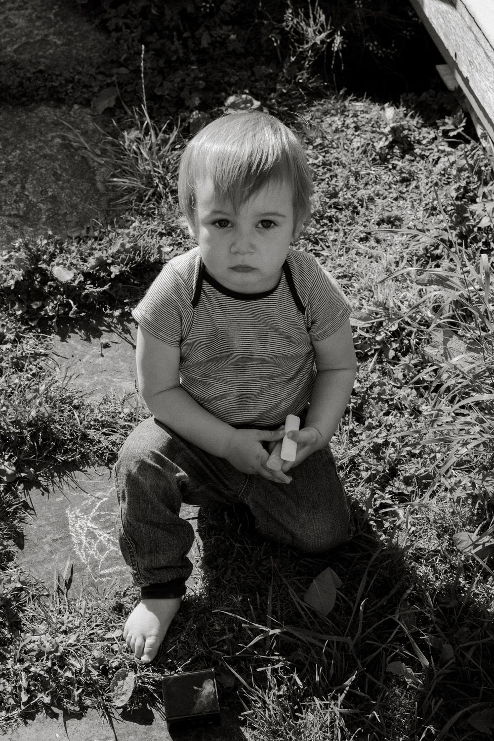 Black and white portrait series of toddler playing outdoors.
