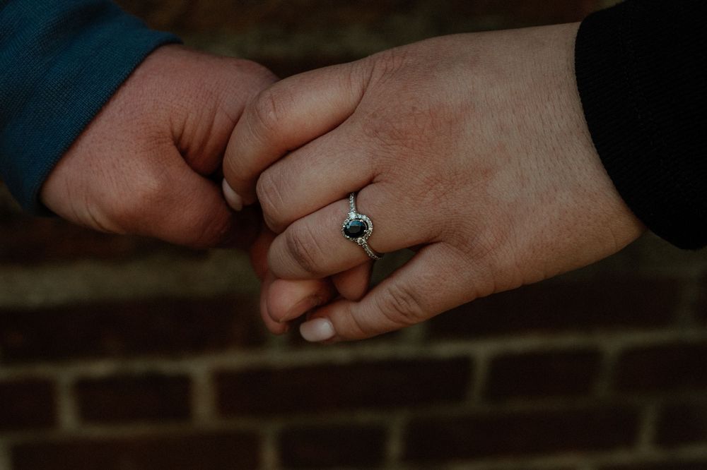 Close-up detail shot of hands with engagement ring.