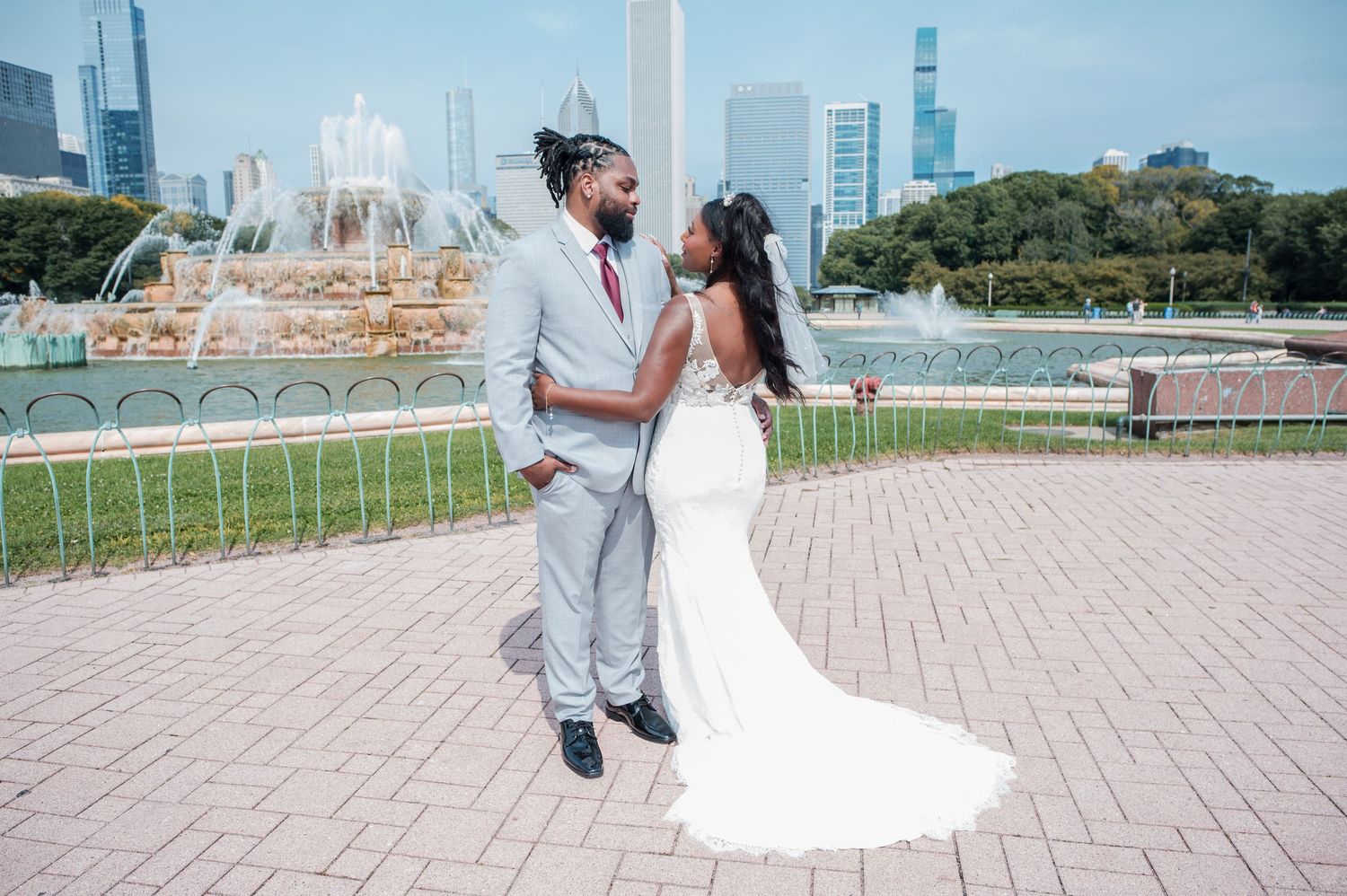 Bride and groom share a romantic moment near Buckingham Fountain in Chicago on their wedding day.