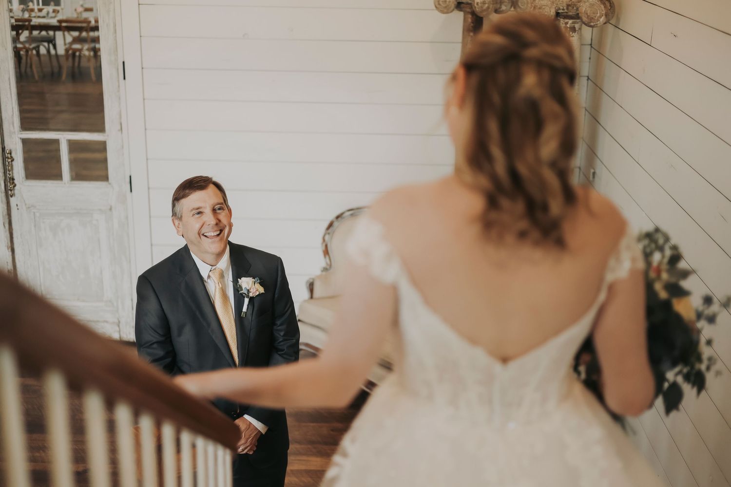 Bride walking downstairs for a first look with her dad at The French Farmhouse