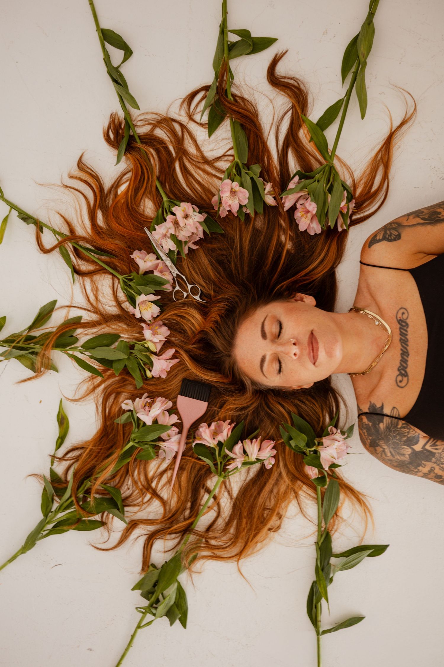 Creative portrait of a woman surrounded by colorful flowers in an artistic floral photography session.