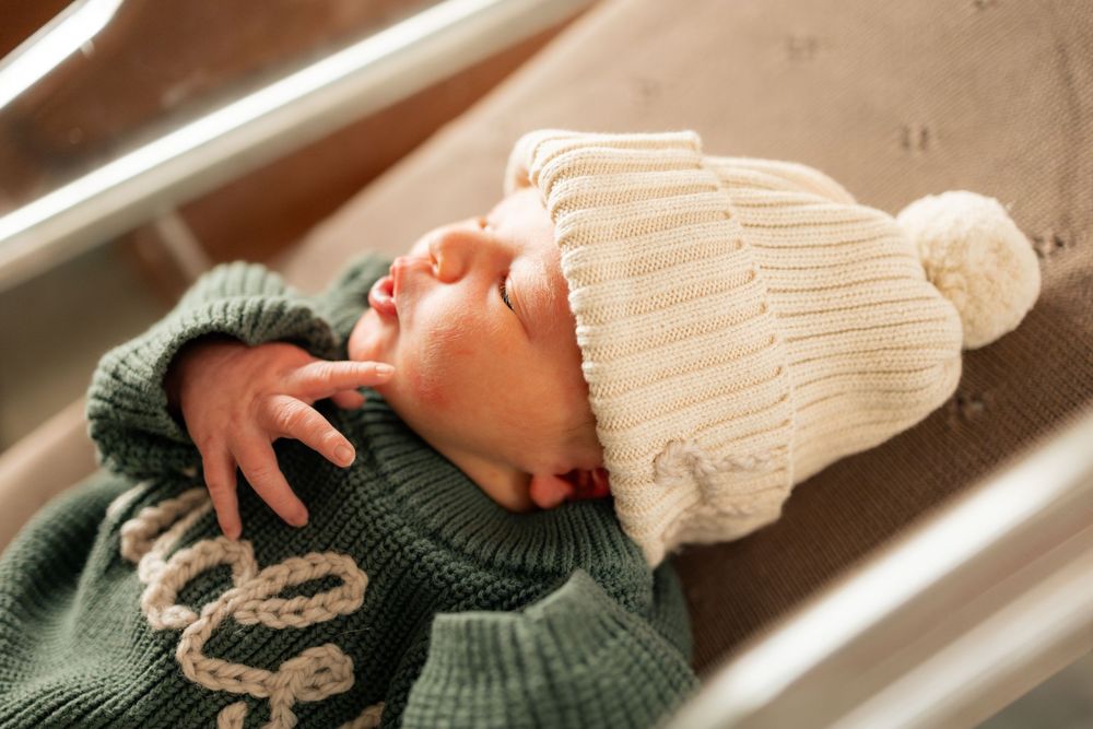 Newborn baby wearing a cream knit pom-pom hat during a Fresh 48 session at Parkwest Medical Center in Knoxville, TN.