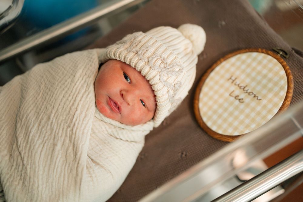 Newborn baby swaddled in cream blanket in their bassinet during a Fresh 48 session at Parkwest Medical Center in Knoxville, TN.