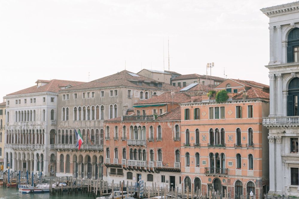 Historic Venetian buildings along the Grand Canal with colorful facades and moored boats in Venice, Italy.