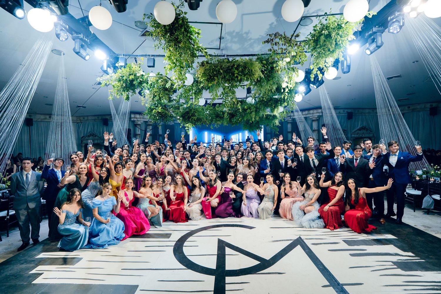 Large group of formal event attendees posing together on stage.