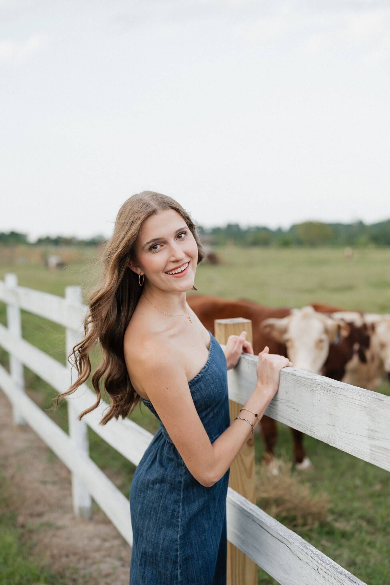 College Park High School senior girl posing on a wooden fence in Magnolia Texas