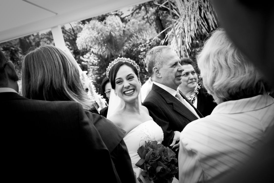 Two women laughing and sharing a joyful moment together at a formal event, captured in black and white photography.
