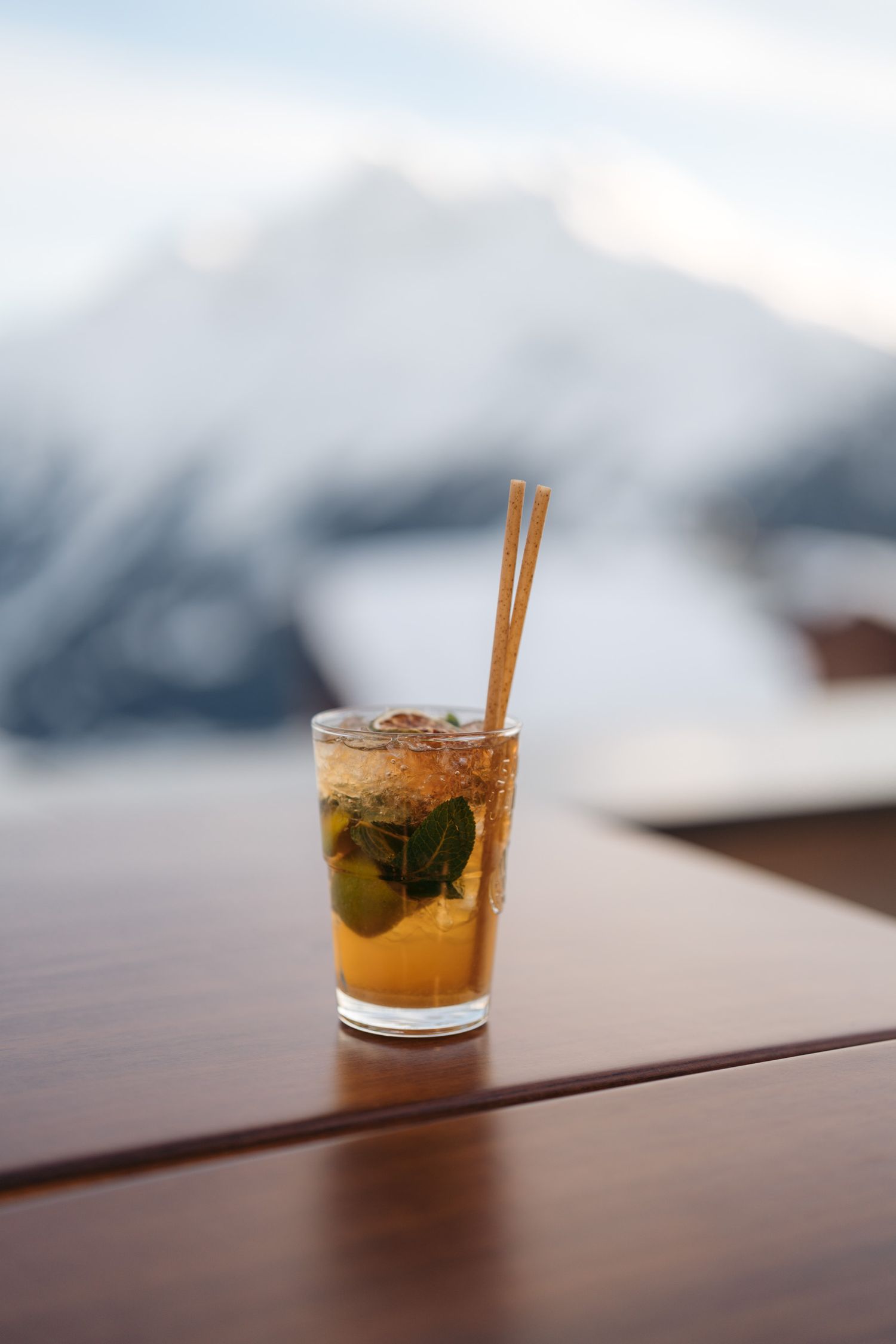 verre de mojito en terrasse avec montagne enneigée en arrière-plan