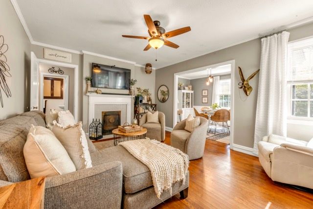 Inviting living room with fireplace, hardwood floors, and natural light photographed for a real estate listing