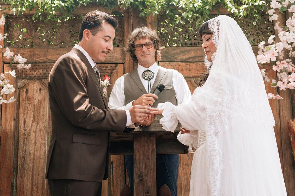 couple exchanging wedding rings at old brown house, film wedding photography