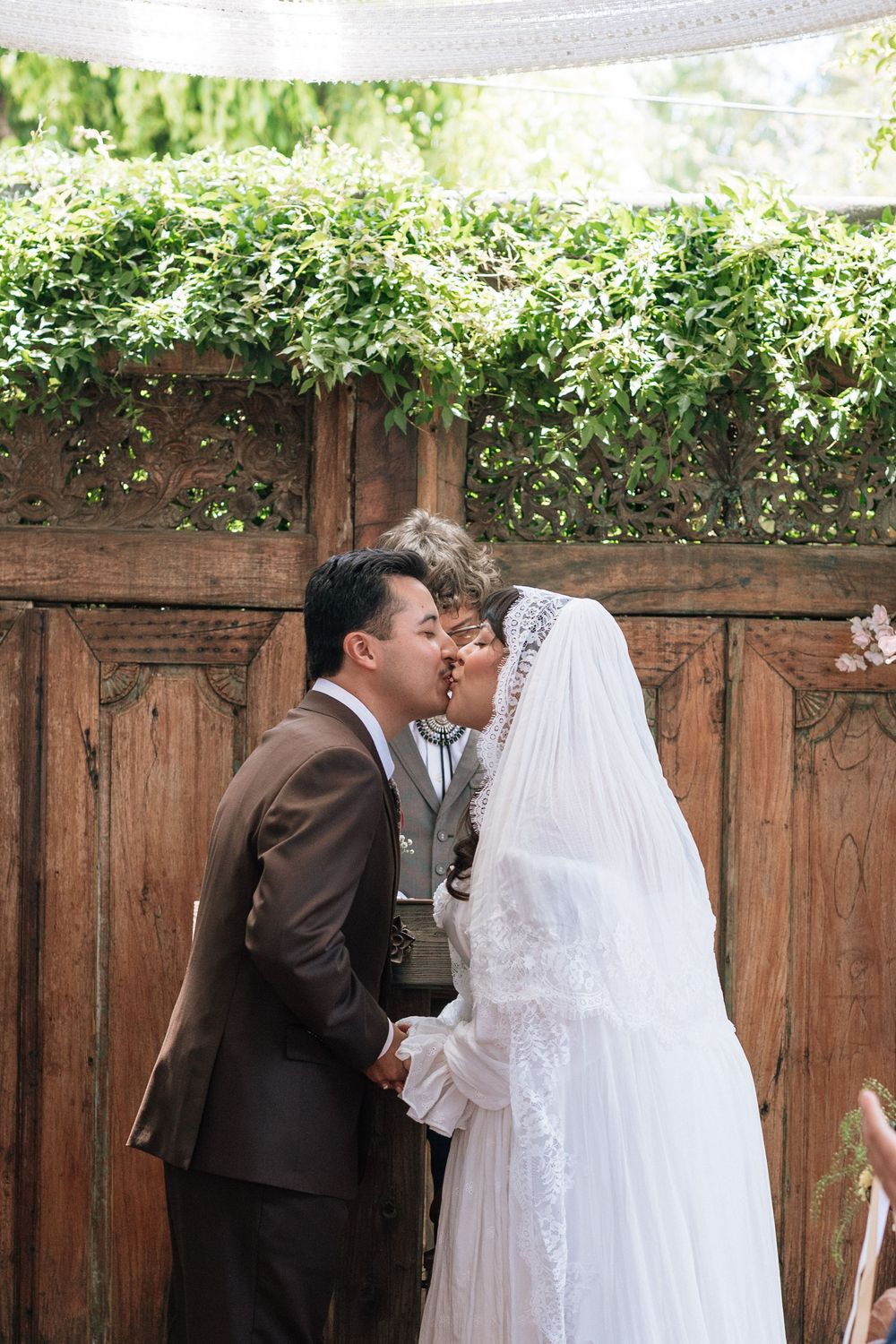 couple kisses at altar of old brown house,film wedding photography