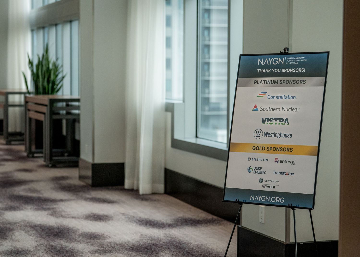 NAYGN sponsor recognition sign on easel in modern conference hall listing Constellation, Southern Nuclear, Vistra, Westinghouse sponsors.