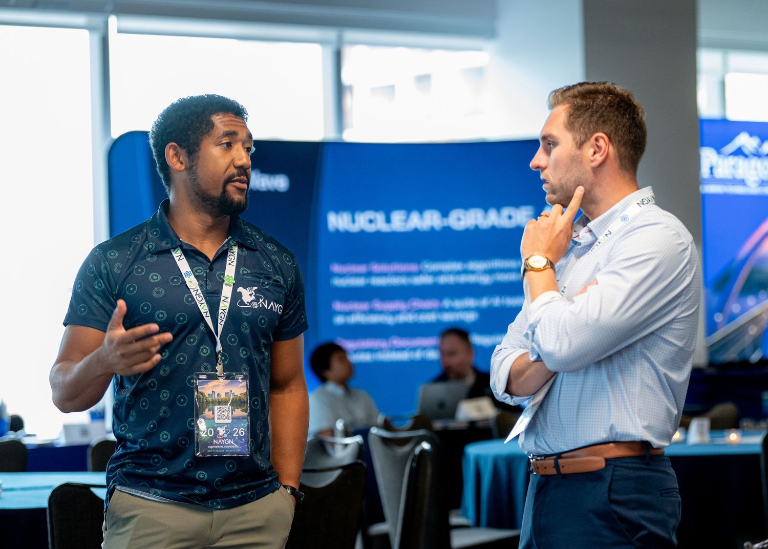 Two professionals engage in conversation at a nuclear energy industry conference networking event.