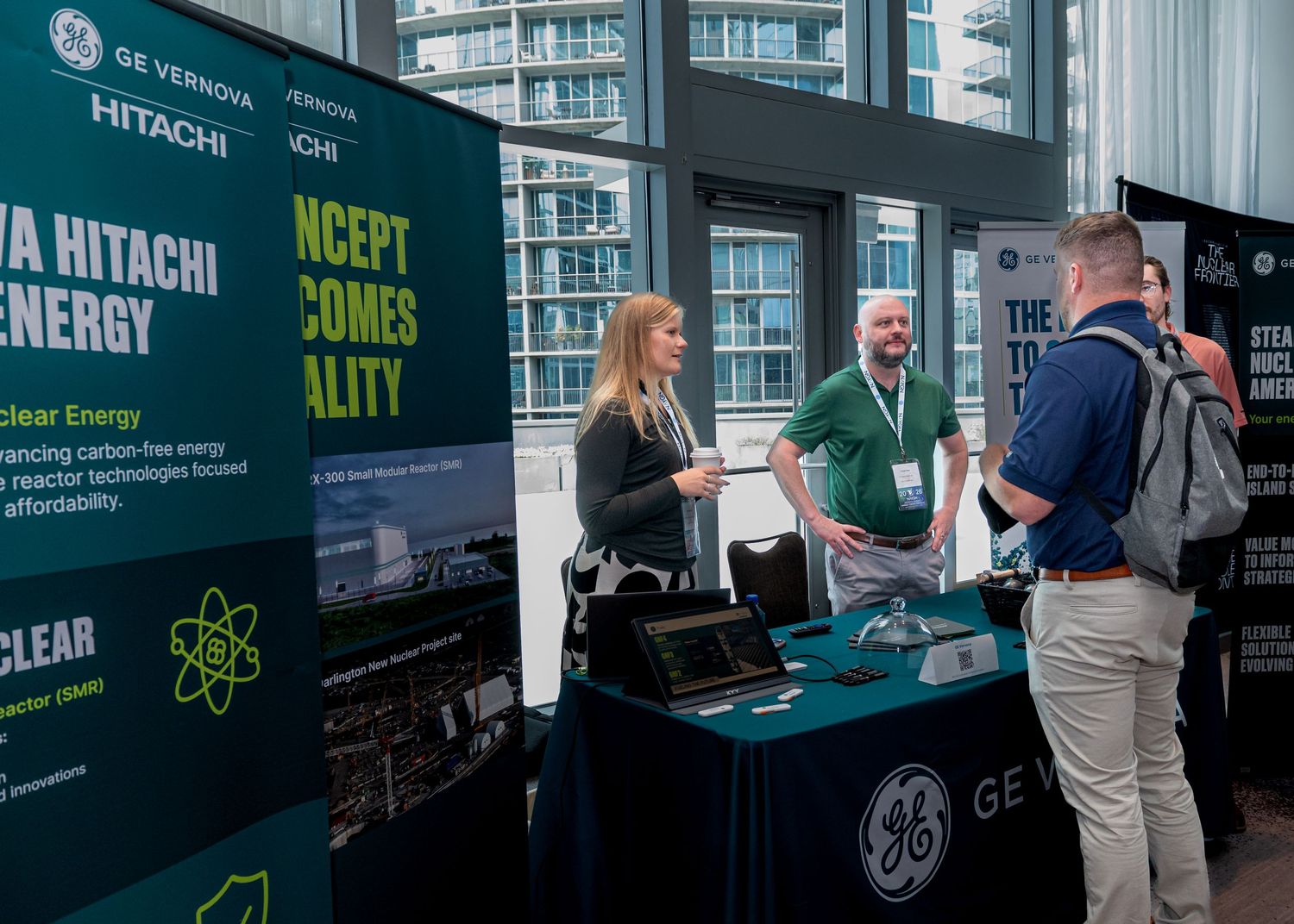 GE Vernova Hitachi Nuclear Energy exhibitors present at a clean energy technology conference booth.
