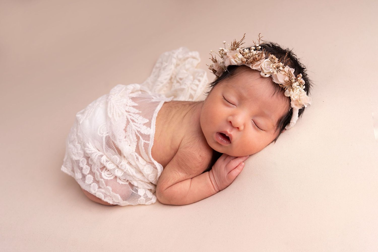 Delicate newborn portraits featuring sleeping baby with tiny hands tucked under chin