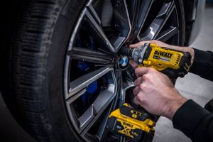 Monteur bevestigt wiel van BMW met elektrische slagschroevendraaier, vastgelegd in een B2B reportage door Bart Boodts Photography.