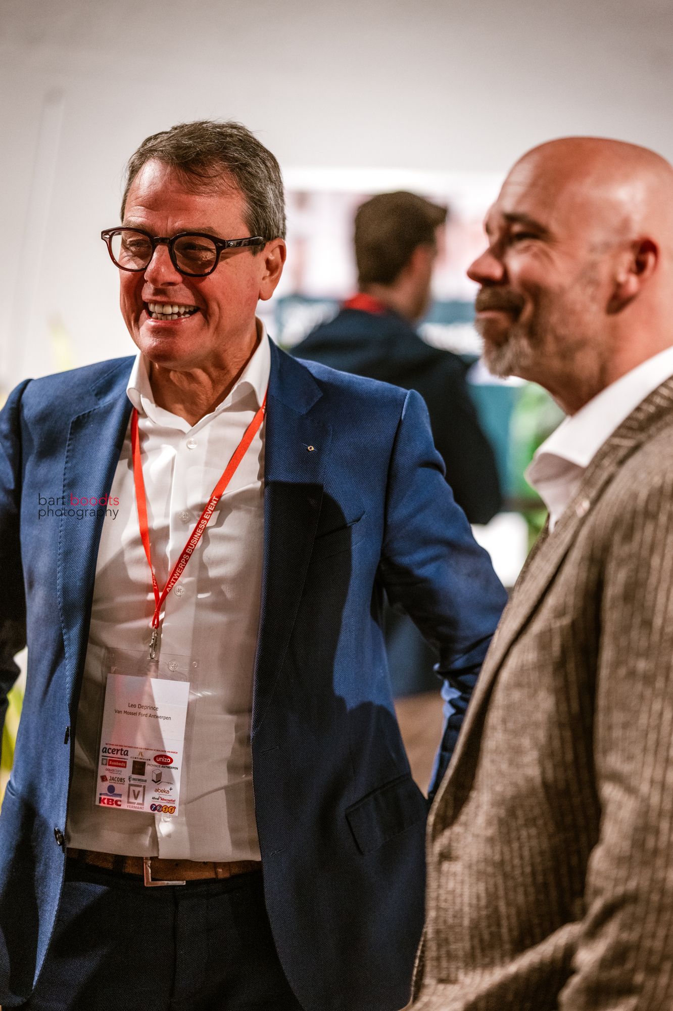 Twee ondernemers in gesprek op een netwerkevent, vastgelegd tijdens een B2B reportage door Bart Boodts Photography.