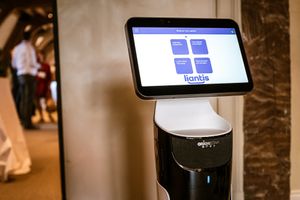 Een robot met een interactief scherm toont het logo van Liantis en biedt opties zoals digitale oplossingen