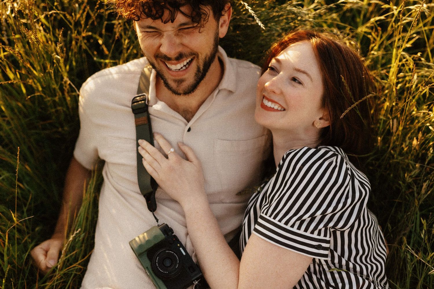 A couple shares joyful moments together in a golden wheat field at sunset.