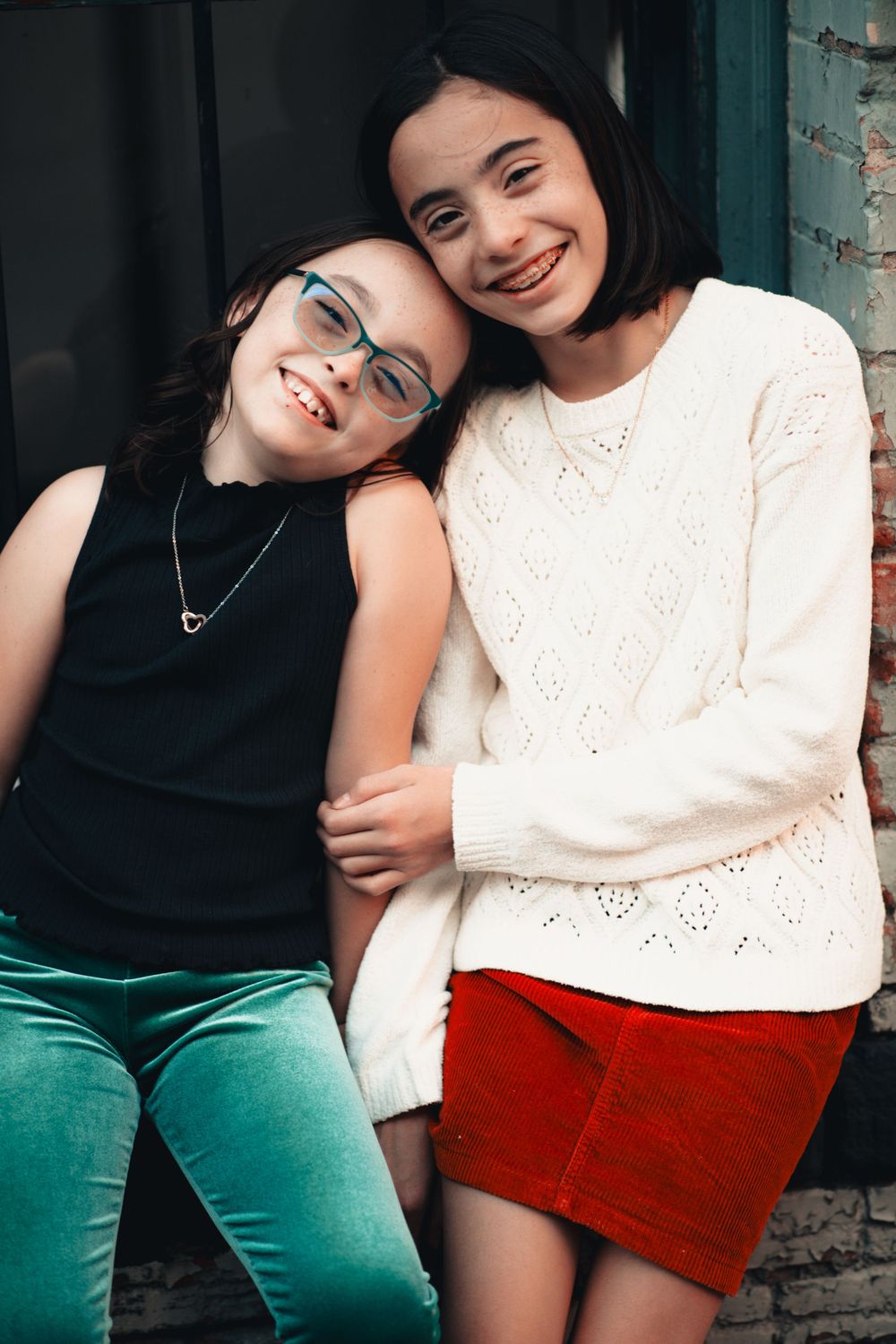 A series of candid photos showing two friends in casual outfits of black and white tops with teal and red bottoms.