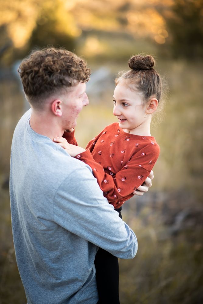 A tender moment captured between two people against a warm sunset background.