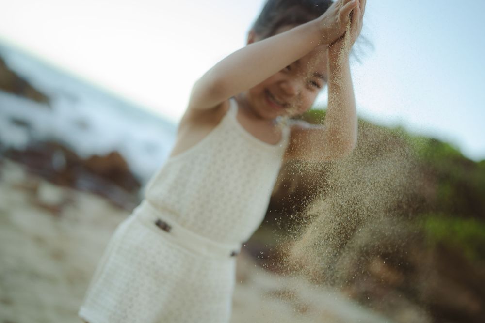 mom and daughter playing at beach during photo shoot in Poipu by Kauai photographer