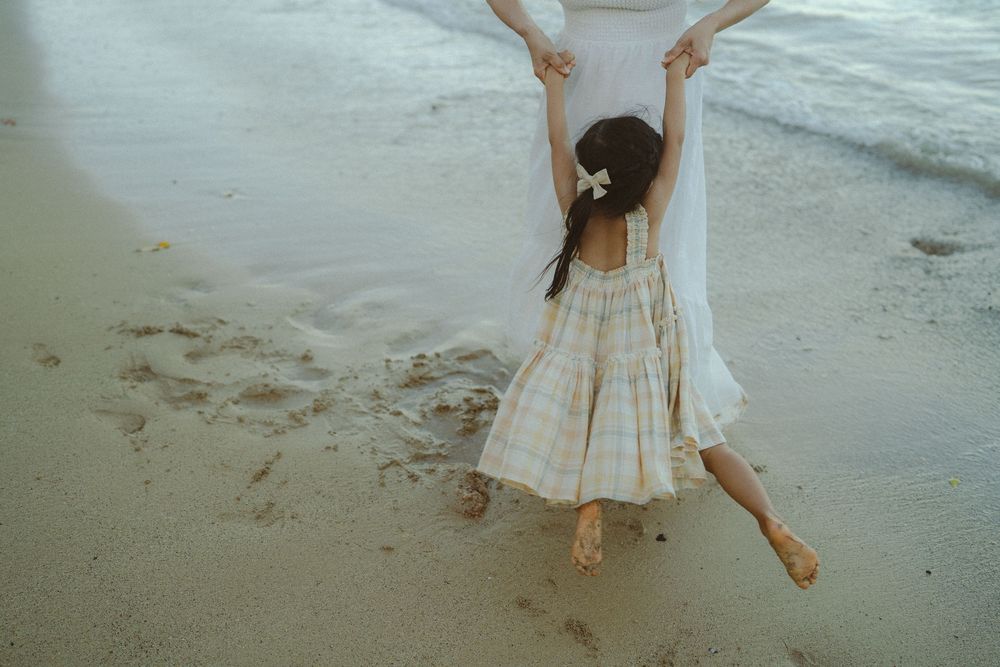 mom and daughter playing at beach during photo shoot in Poipu by Kauai photographer