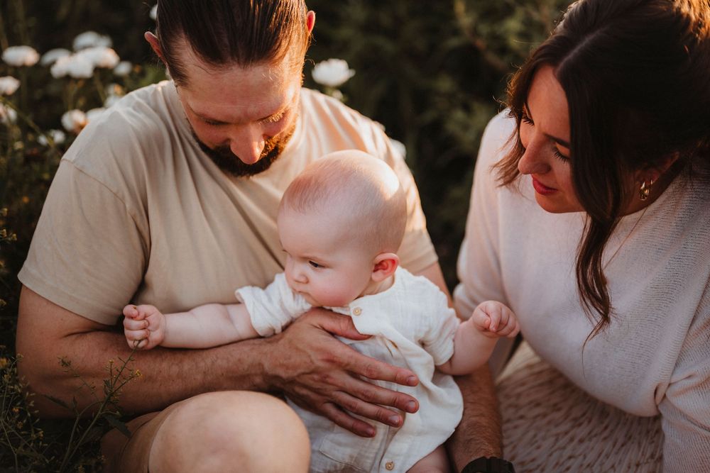 A series of intimate family photos showing tender moments between parents and their newborn baby in warm lighting.