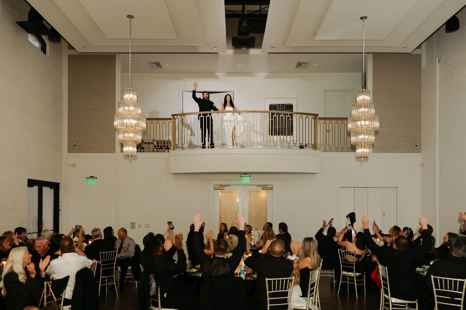 Bride and Groom wave to their guests from the balcony at Clay Theatre to make their grand entrance into their wedding reception.