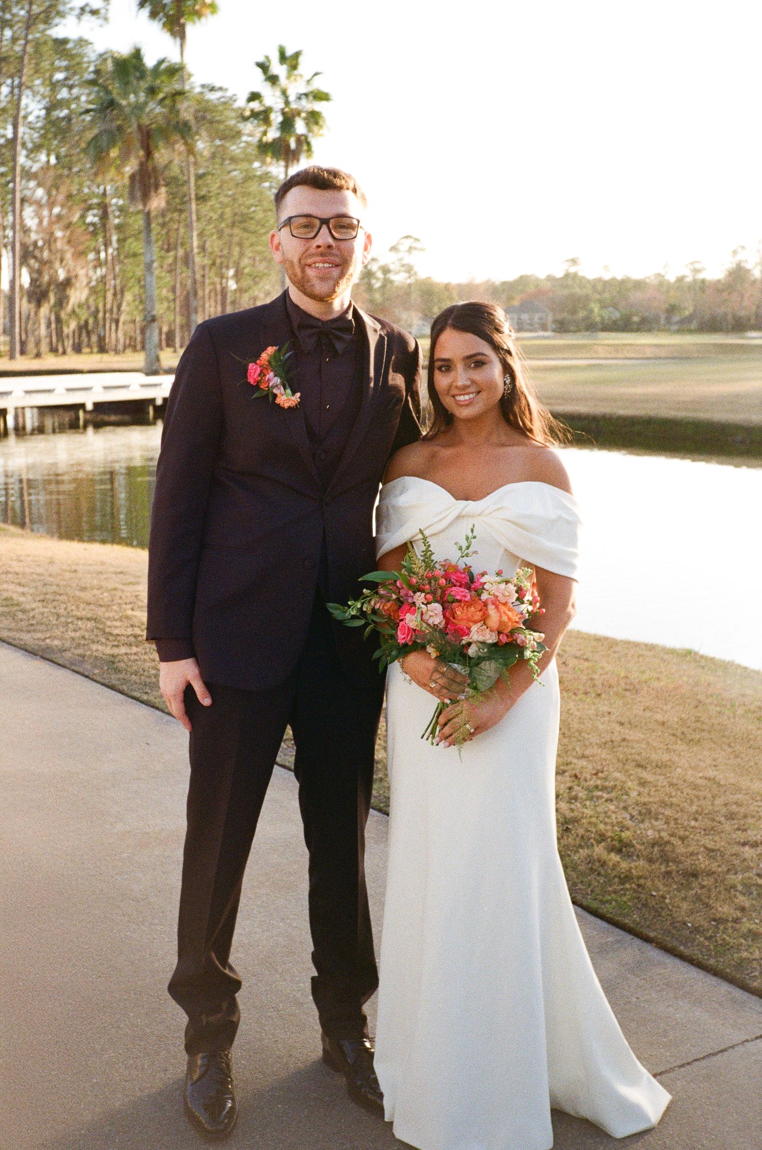 35mm film photo of the bride and groom taking a traditional couples portrait for their golf course wedding day.
