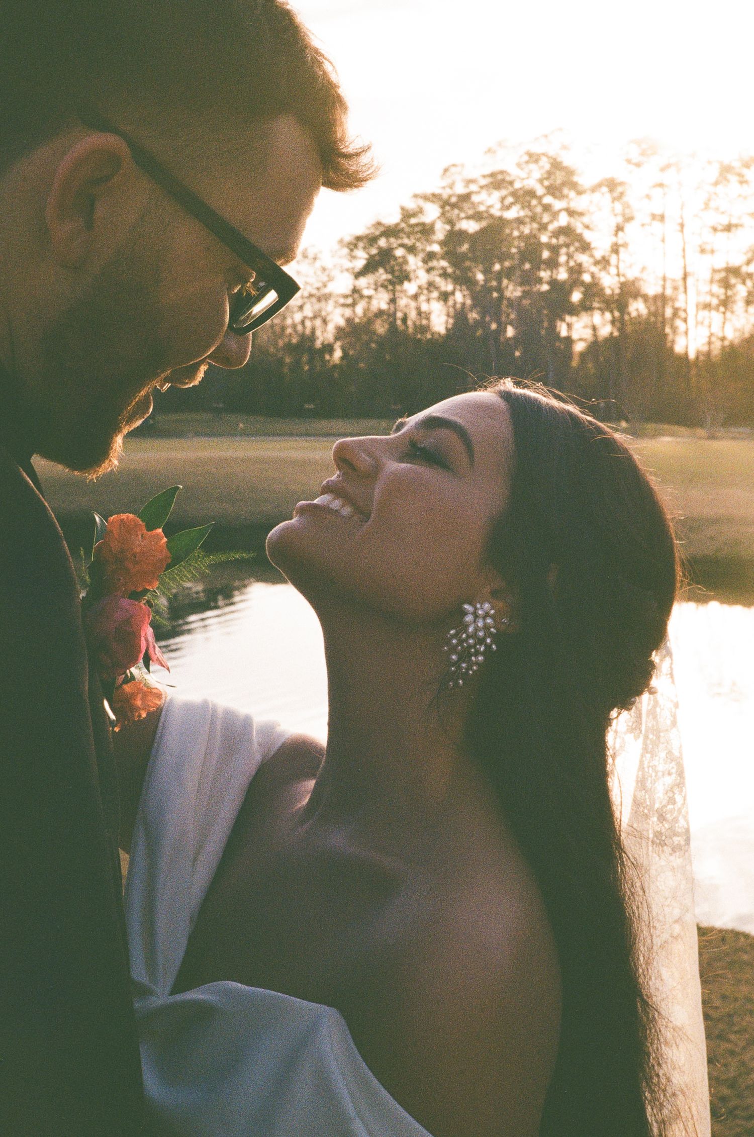 35mm film photo of the bride and groom smiling at each other right before the sun set during their golf course wedding day.