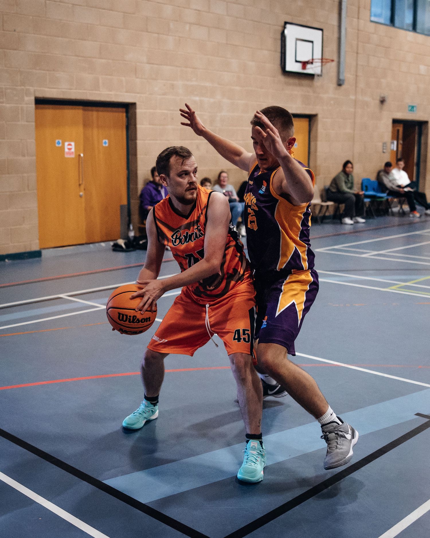 Basketball players battle for position during intense indoor game play.