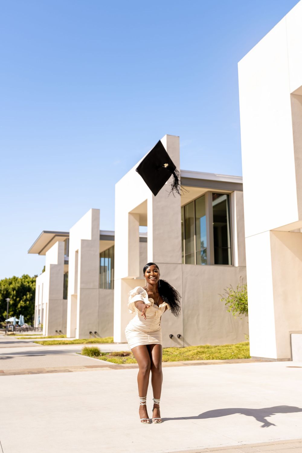 A sequence of four photos showing someone playfully running and hiding between white modern architectural structures.
