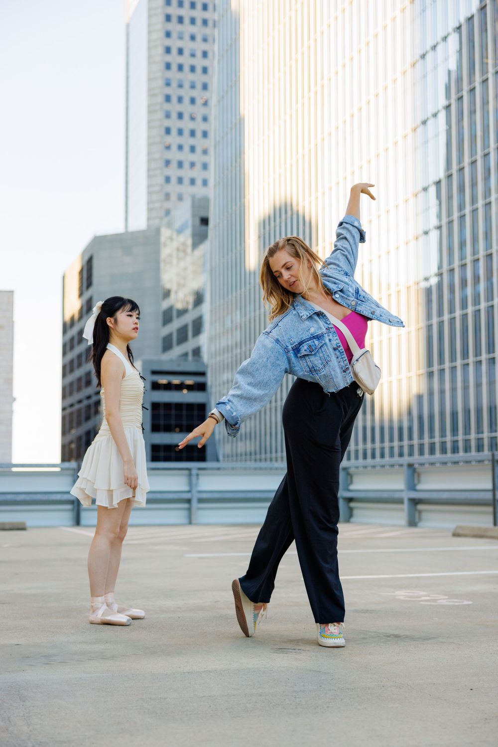 Urban dancers performing expressive movements on a rooftop with skyscrapers in the background.