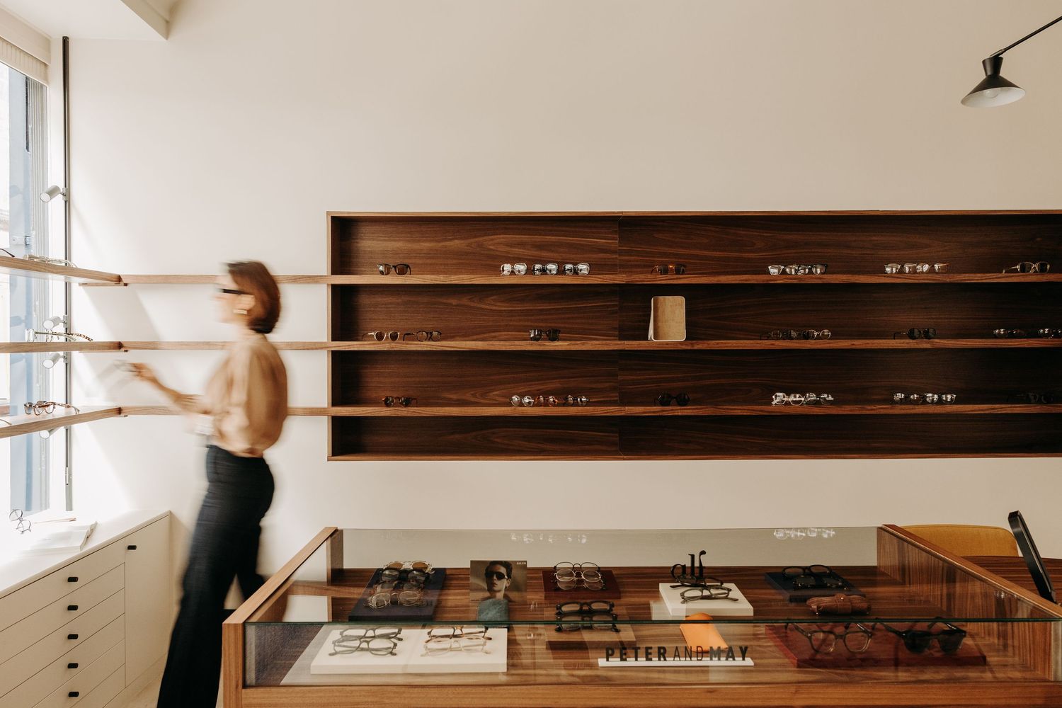 Minimal retail space with white display tables and wooden accents featuring a modern, bright interior design.