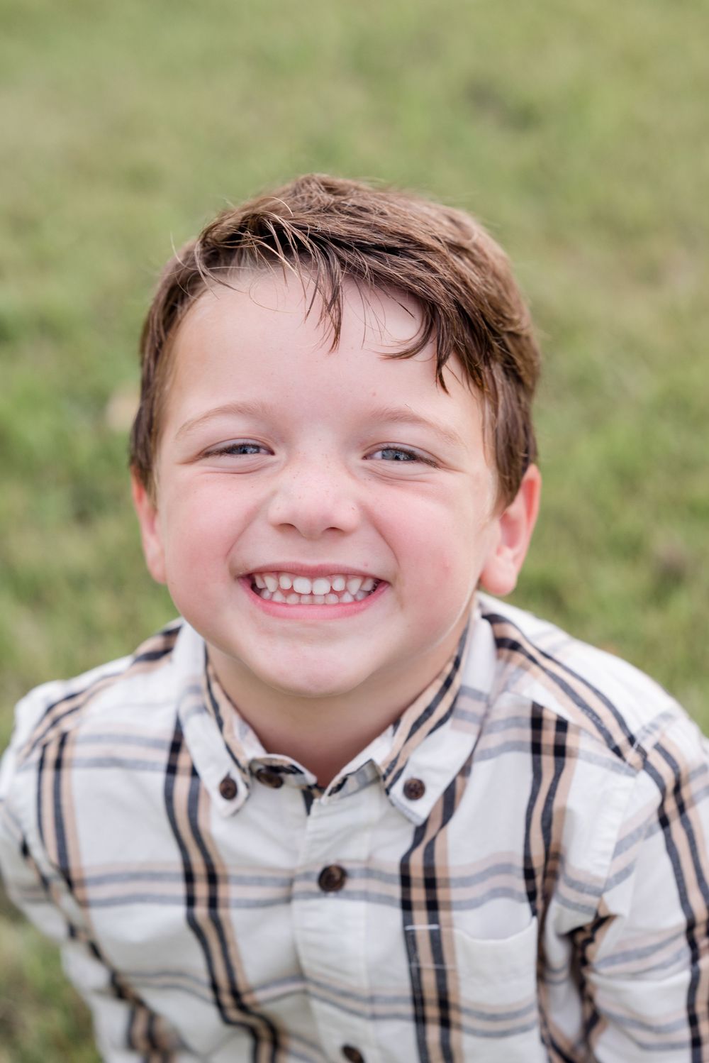 A close-up portrait showing joyful expressions in a plaid shirt.