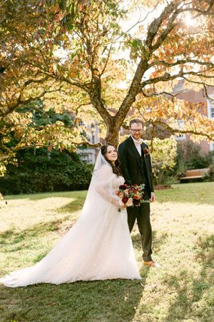 A romantic autumn wedding photoshoot under golden trees with sunlight streaming through the branches.