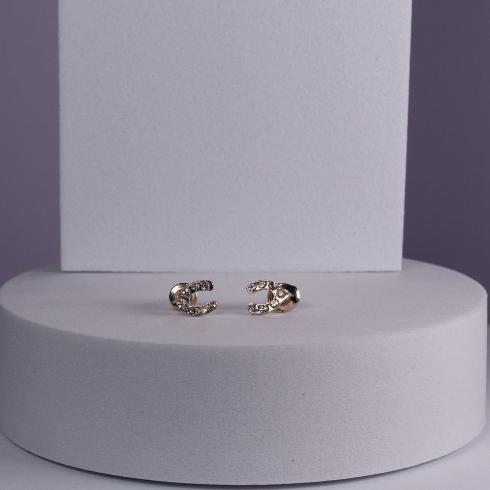 Delicate gold ring with ornate tiger head design displayed on white pedestal.