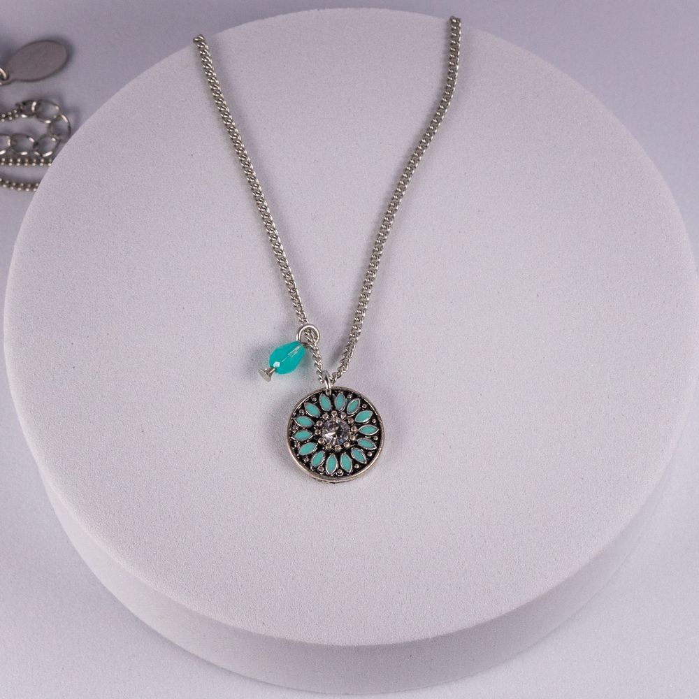 Silver chain necklace with turquoise stone and circular medallion pendant.